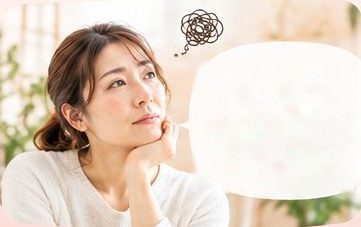 頬づえをついて考え込む女性