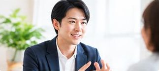 保護者の話に笑顔で耳を傾ける男性の相談員