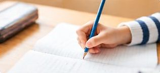 ノートに鉛筆で書き込む子どもの手元